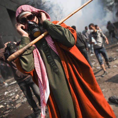 Một người biểu tình ăn vận theo phong cách truyền thống, đeo mặt nạ phòng độc và kính râm khổ lớn. Ảnh: AP